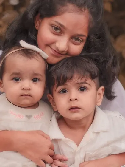 A classic portrait of three siblings looking towards the camera. Their curious and innocent expressions make this a truly special and memorable photograph.