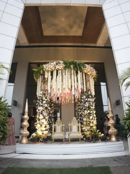 A unique seating arrangement designed for the wedding ceremony, featuring ornate chairs under a canopy of hanging floral strings. This setup at Karma Lakelands provided a beautiful photo opportunity for the couple.