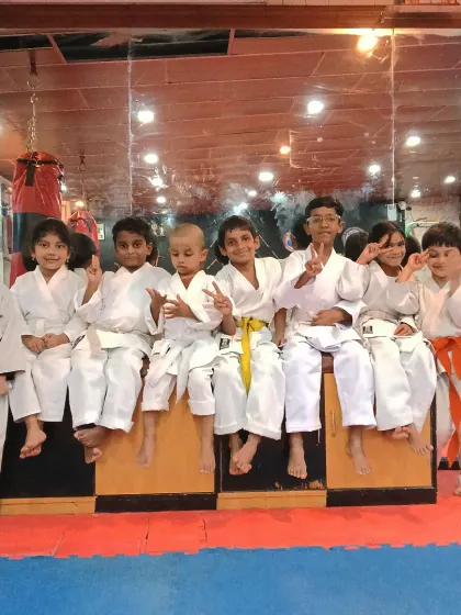 My students, a team of young martial artists, posing together in their karate gi uniforms. Each belt color represents a step forward in their journey.