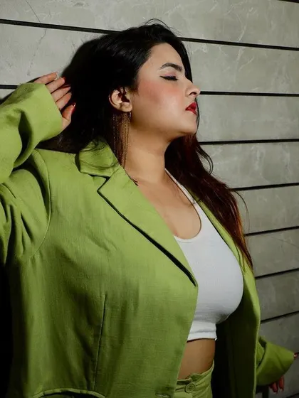 A moody, side-profile shot of a model in a green blazer, using dramatic lighting to create a high-fashion, editorial feel.