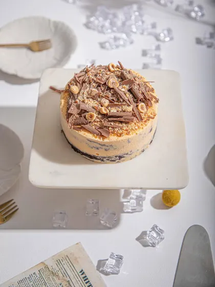 An overhead view of our Mango and Chocolate ice cream cake, showcasing the generous topping of chocolate shavings and hazelnuts.