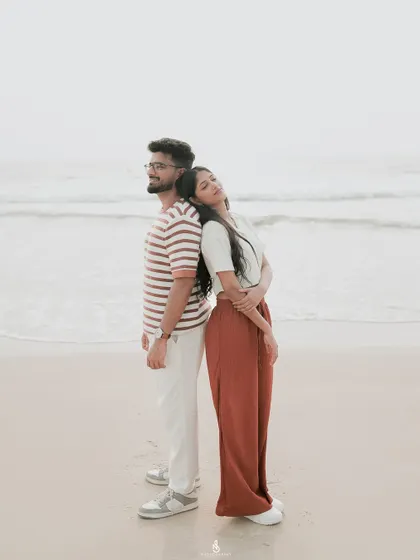 A serene pose, standing back-to-back against the calming ocean waves. This composition adds a sense of balance and quiet strength to the portrait.