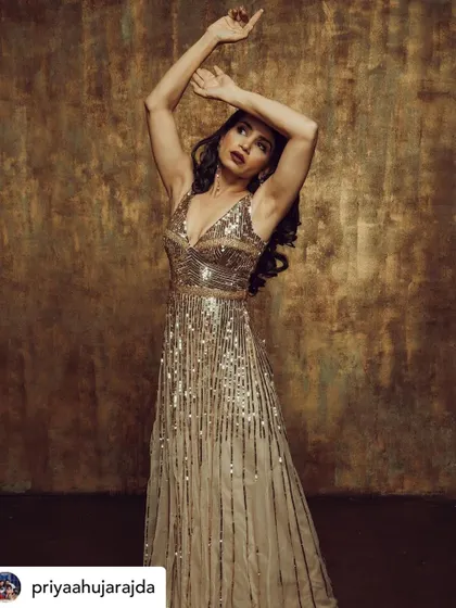 An artistic and expressive pose. The makeup is designed to highlight her features and look stunning under studio lighting.