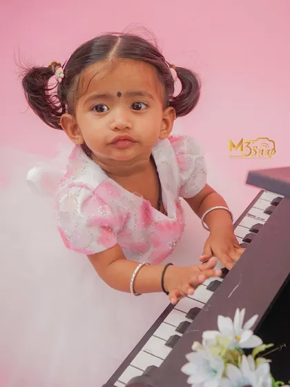 An adorable overhead shot of the little pianist. Her pigtails and sweet expression add to the charm of this creative toddler photoshoot.
