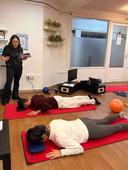 Learning to teach involves observing and guiding others. A trainee instructor takes the lead, guiding her classmates through a prone series while I observe and prepare to give feedback.