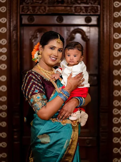A beautiful mother holds her baby close during a naming ceremony. This portrait captures the divine bond between mother and child.