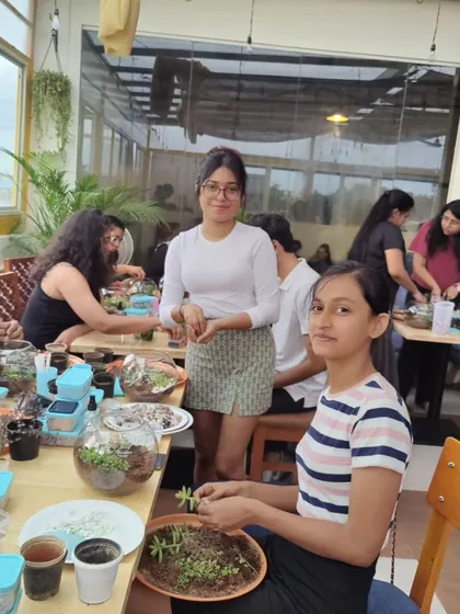 Two participants focused on arranging plants and decorative elements in their terrariums. I provide a wide range of materials so everyone can customize their creation.