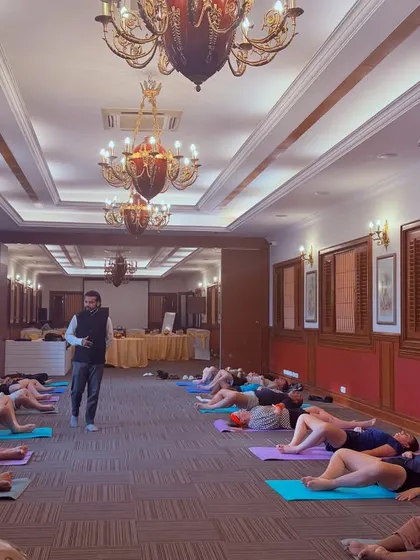 A large group of employees resting during a sound bath in a hotel conference room.