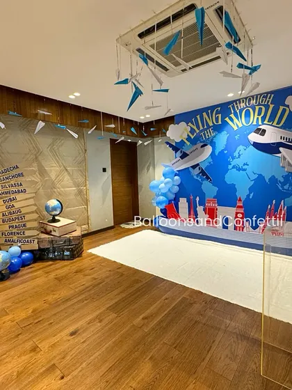 The complete travel-themed setup, with paper airplanes hanging from the ceiling and a corner dedicated to globes and vintage suitcases.