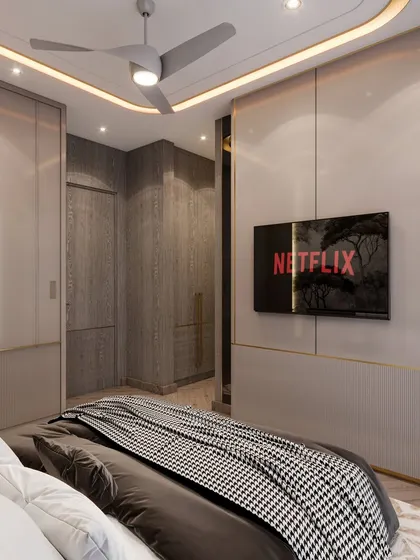 The TV wall in the guest room, featuring sleek, handleless wardrobes with golden inlay details. The design is clean and modern, maximizing storage while maintaining a sophisticated look.