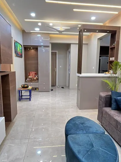 An overview of the open plan living and dining area, showing the TV unit, mandir, and partition working together.