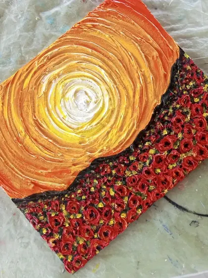 An angled view of the textured sunset and rose field painting. This perspective highlights the raised surfaces and shadows, which is the unique appeal of creating tactile art with texture paste.