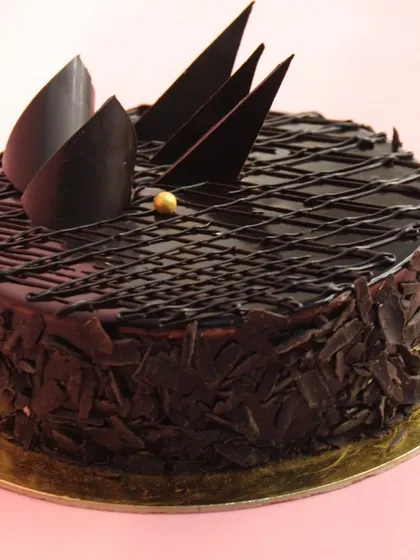 An elegant take on our best-selling eggless chocolate cake, decorated with sharp chocolate shards and delicate chocolate shavings around the base.