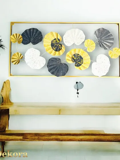 A framed wall art piece with an abstract leaf design in black, white, and gold. The contained composition makes it a great choice for a more formal living room or office.
