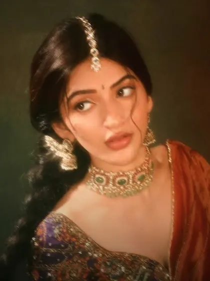 The ethereal Sree Leela in a vintage-inspired portrait, wearing a green beaded choker, winged earrings, and a delicate maang tikka.