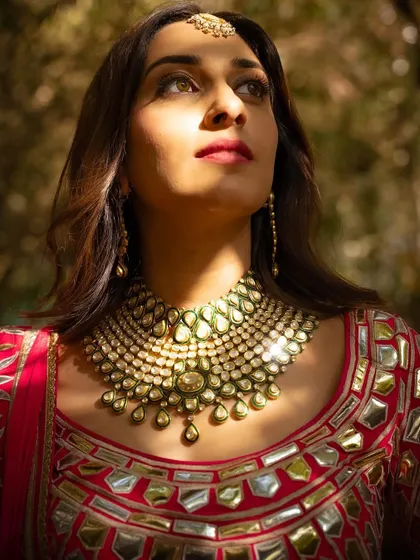 An artistic shot highlighting the beautiful makeup and statement jewelry. The soft, luminous skin catches the light perfectly, creating a truly radiant effect.