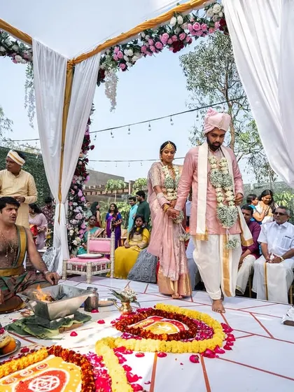 The couple taking their pheras around the sacred fire. The mandap is designed to be open and airy, allowing guests to feel connected to the ceremony.