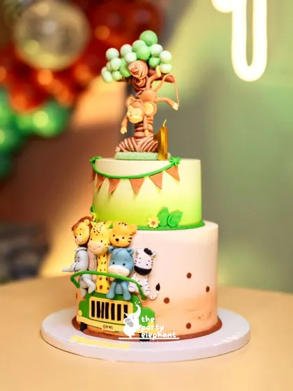 The amazing two-tiered jungle safari cake, featuring a safari jeep full of animals on the bottom tier and a monkey swinging from a tree on top.