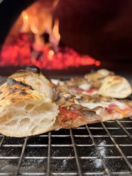 A slice of heaven resting on the grill, with the wood fire roaring in the background. This is where the magic happens.