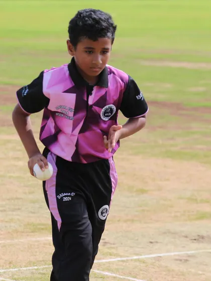 A young bowler gets ready to deliver the ball during a competitive Dasara Cup game.
