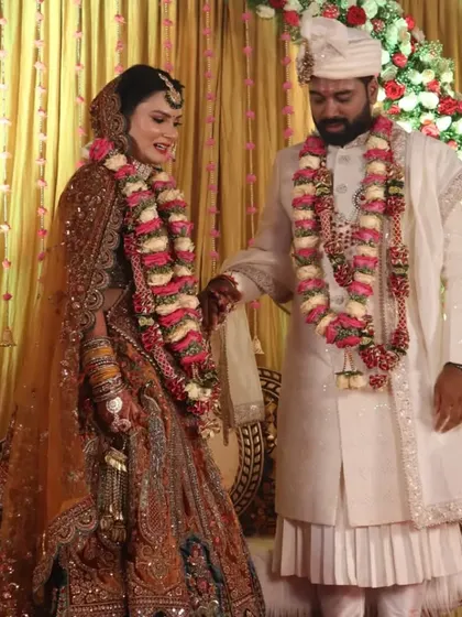 A couple poses on their beautiful reception stage. We work to create the perfect backdrop that not only looks great in person but also makes for stunning wedding photography.