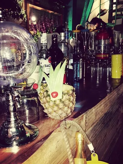A closer look at the details of a molecular bar setup. You can see unique glassware, a pineapple garnish, and a globe infuser, all part of creating an experimental cocktail experience.