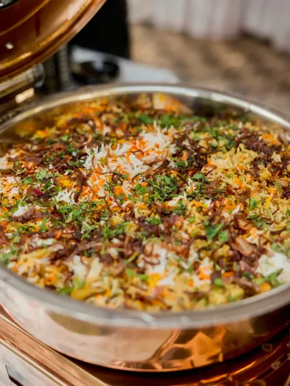 A close up of my traditional vegetable biryani in a copper serving dish. The colourful rice, fried onions, and fresh herbs make it a visually appealing and delicious main course.