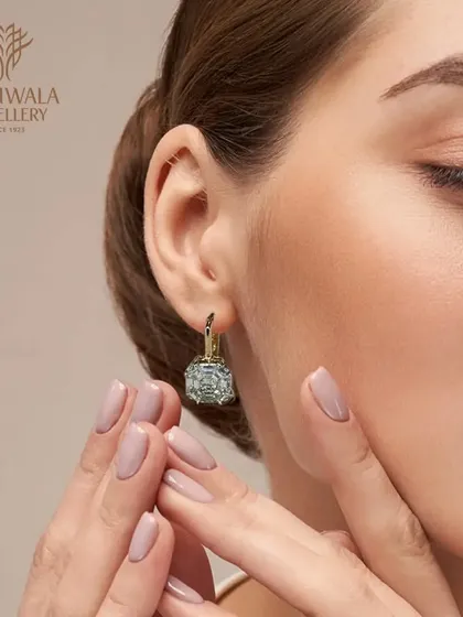 A model wearing elegant diamond drop earrings with a unique square illusion setting. These are a modern and sophisticated choice for everyday luxury.