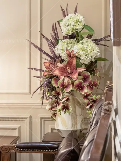 This fresh assortment of artificial blooms, featuring lilies and hydrangeas, is designed to bring charm and color to your tabletops. The arrangement adds a touch of drama and elegance to this classic corner.