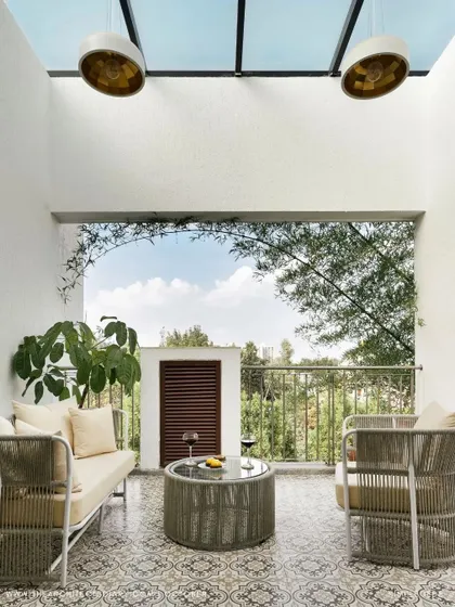 This semi-outdoor space in 'A Walk in the Clouds' features a glass roof, patterned flooring, and a view of the bamboo garden, creating a light-filled, tranquil retreat.