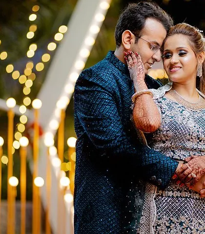 An intimate engagement portrait. The couple's close embrace and the warm bokeh background create a dreamy and romantic mood.