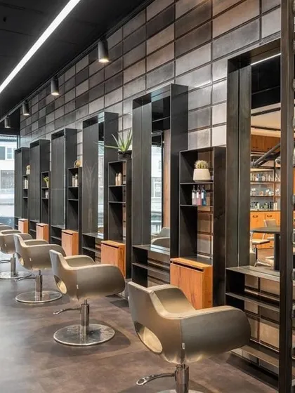 This is an example of a modern, industrial salon design. I used concrete-style wall tiles, black metal framing for the stations, and simple track lighting to create a sleek, urban, and edgy look.