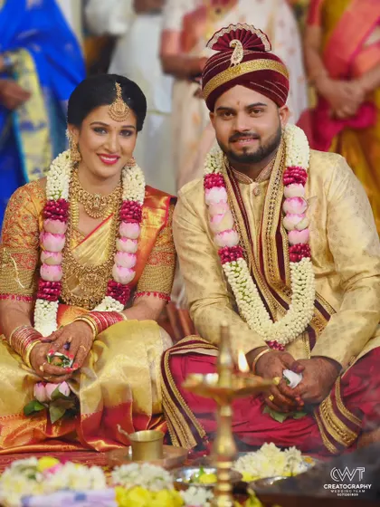 A classic portrait of a couple during their wedding puja, seated before the sacred lamp, capturing the spiritual essence of the ceremony.