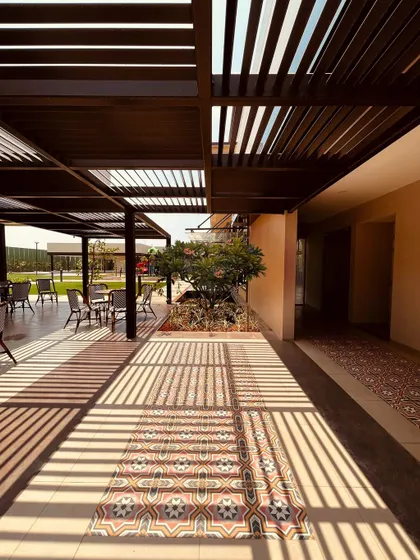 The shadows from the pergola create a graphic pattern on the floor, turning a simple walkway into a visual experience.