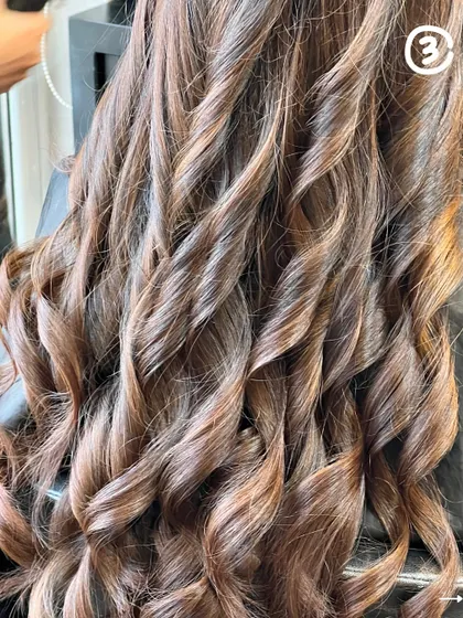 A close-up of a stunning hair transformation. The curls are defined, the color is rich, and the hair looks incredibly healthy.