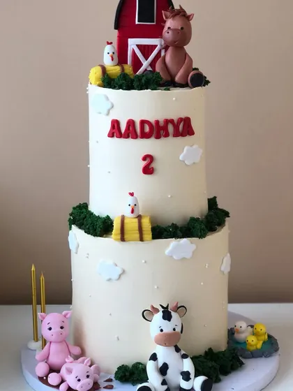 A classic farm animal cake, with a red barn, horse, cow, and pigs. A fun theme for a second birthday.