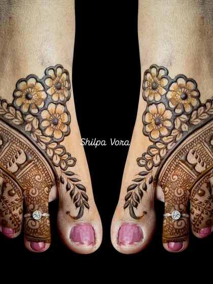A beautiful floral foot design. The pattern elegantly frames the top of the foot with blooming flowers and leafy vines.