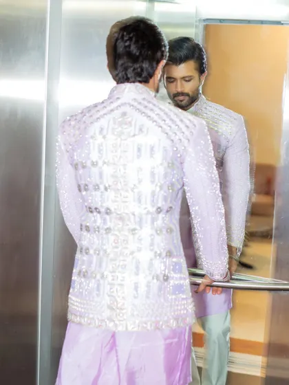 A creative shot showing Vijay's reflection. The mirror captures the stunning back detailing of the Papa Don't Preach jacket, which is covered in intricate beadwork.