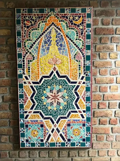 This beautiful mosaic artwork brings color and intricate detail to an industrial-style brick wall. The contrast between the rustic brick and the refined, colorful tiles creates a dynamic and unexpected feature, adding a layer of history and craftsmanship to the space.