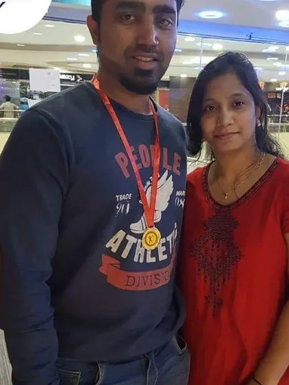 This couple celebrates a successful archery session. The gentleman proudly wears his medal, marking a great day of sport.