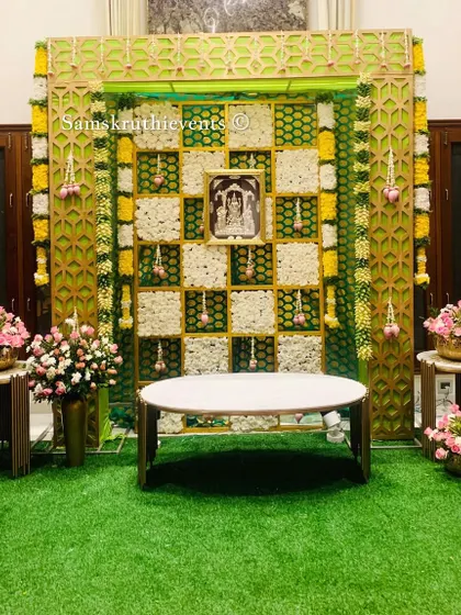 A full view of our elegant green and white floral backdrop. The artificial grass flooring and side floral arrangements complete the look, creating a perfect photo opportunity for your special day.