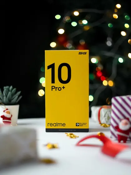 The realme 10 Pro+ 5G box featured in a Christmas themed product shot, surrounded by gifts and decorations.