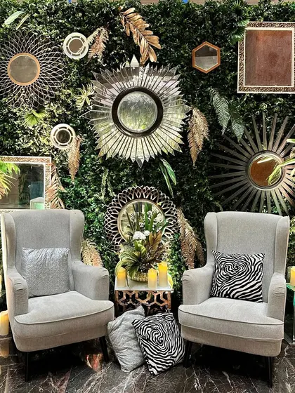 The full view of the enchanted mirror photo booth, with two elegant armchairs inviting guests to sit and capture a magical moment.