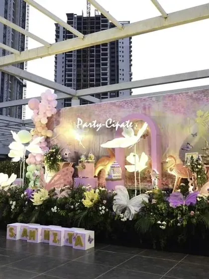 A wide view of Samhita's butterfly-themed party on a rooftop venue. The setup is framed by the city skyline, showing how we can create an enchanted space anywhere.