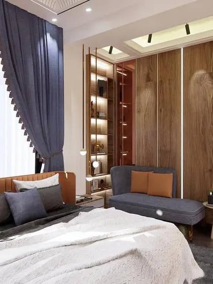 We added drama to this guest bedroom in Greater Noida with a fancy POP ceiling and a feature wall of wood and mirrors. The design uses warm lighting and a cozy daybed to create an inviting atmosphere.