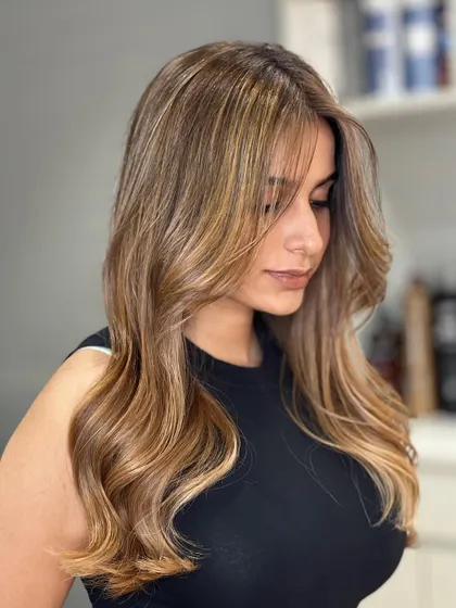 A beautiful profile of our blonde Airtouch Balayage. The color frames her face perfectly and the soft waves add a touch of glamour.