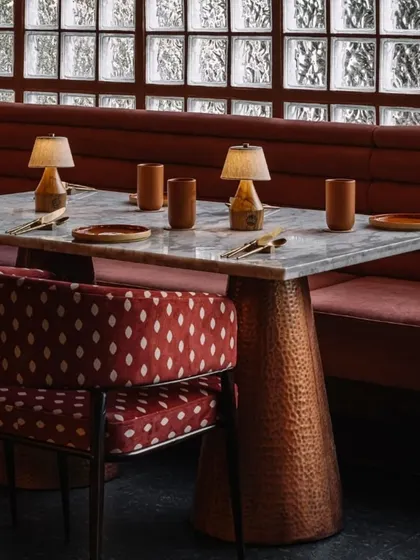 A detail of the custom furniture at Idylll. The hammered copper table base, marble top, and patterned upholstery reflect our commitment to craft and materiality in every aspect of the design.