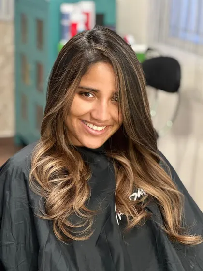 A portrait of the smiling client, looking radiant with her new hair.