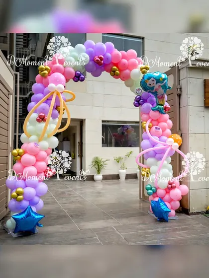 A whimsical balloon arch for a mermaid party, using a bright and fun color palette of pink, purple, and yellow with mermaid tail accents.