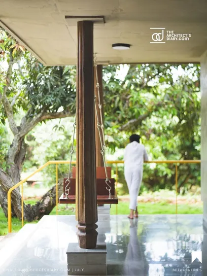 A traditional wooden swing on the verandah of "Aamra," looking out into the lush greenery. This element is a nod to vernacular Indian architecture, creating a perfect spot for relaxation.
